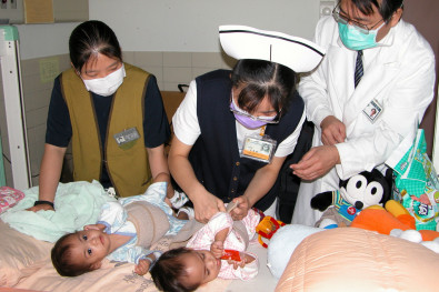 2003年，呂基燕(中)細心照顧花蓮慈院第一對來自菲律賓進行分割手術的連體女嬰慈恩、慈愛