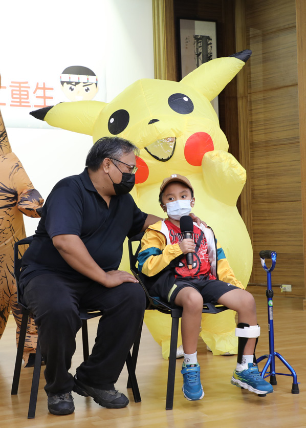 男孩康復後出席醫院公益活動，與家人一同露出笑容
