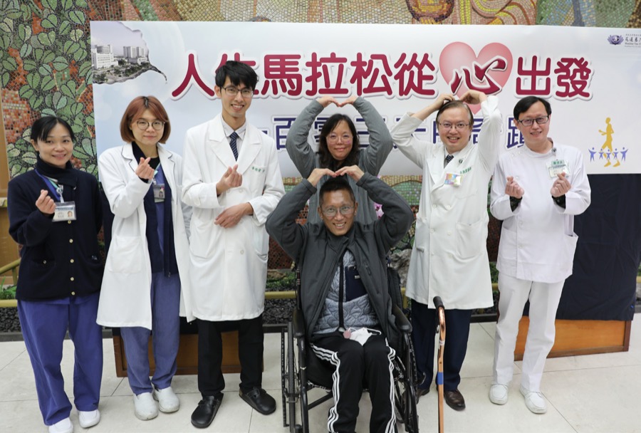 黃先生與醫療團隊在康復成果發表活動上合影，比出愛心手勢