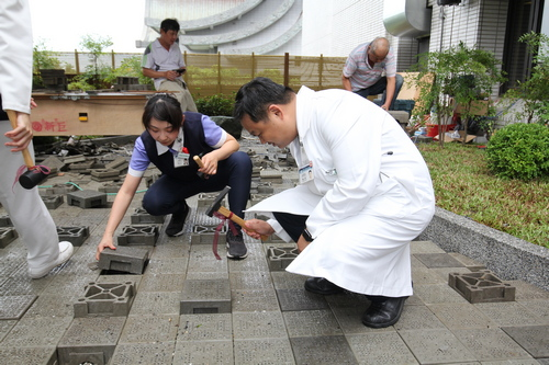 左圖：花蓮慈院家庭醫學部緩和醫療科主任謝至鎠(右)將連鎖磚敲實敲平。 右圖：花蓮慈院副院長許文林(右)與慈濟志工顏惠美(左)一起鋪下環保磚。