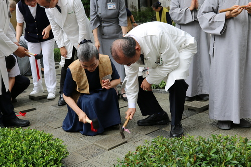 左圖：花蓮慈院家庭醫學部緩和醫療科主任謝至鎠(右)將連鎖磚敲實敲平。 右圖：花蓮慈院副院長許文林(右)與慈濟志工顏惠美(左)一起鋪下環保磚。