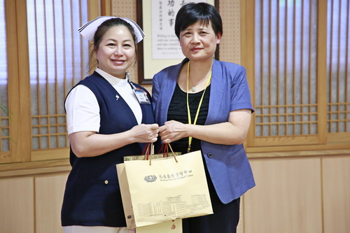華中科技大學同濟醫學院醫藥衛生管理學院劉義蘭教授（右），分享關懷理論，花蓮慈院護理部主任鍾惠君（左）送上結緣品