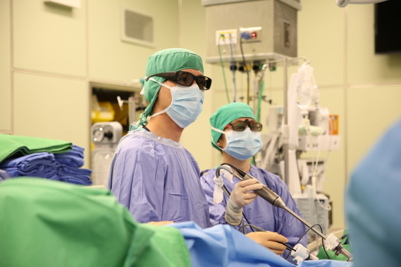 大腸直腸外科施廷翰醫師（左）配戴3D偏光眼鏡，為患者進行3D立體腹腔鏡手術切除大腸腫瘤