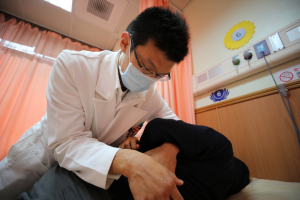 花蓮慈院中醫部主治醫師沈炫樞為患者進行推拿整復治療。