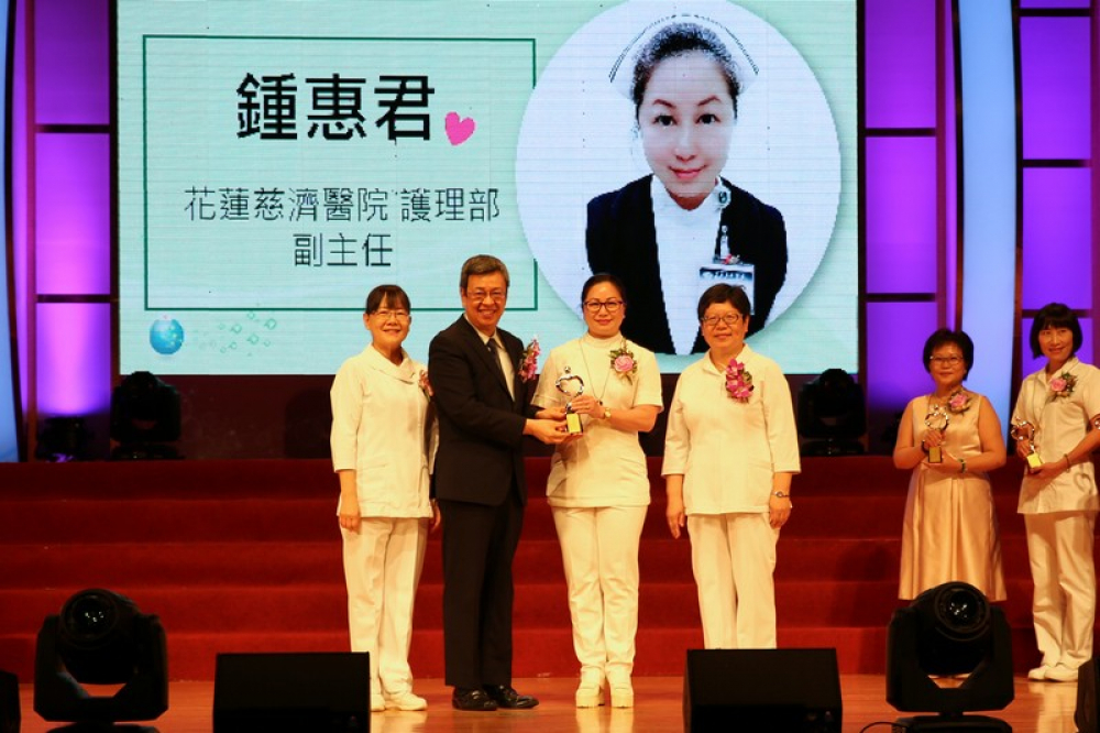 花蓮慈濟醫院護理部副主任鍾惠君（右二）從副總統陳建仁（左二）手中頒發全國護理人員「服務奉獻獎」。