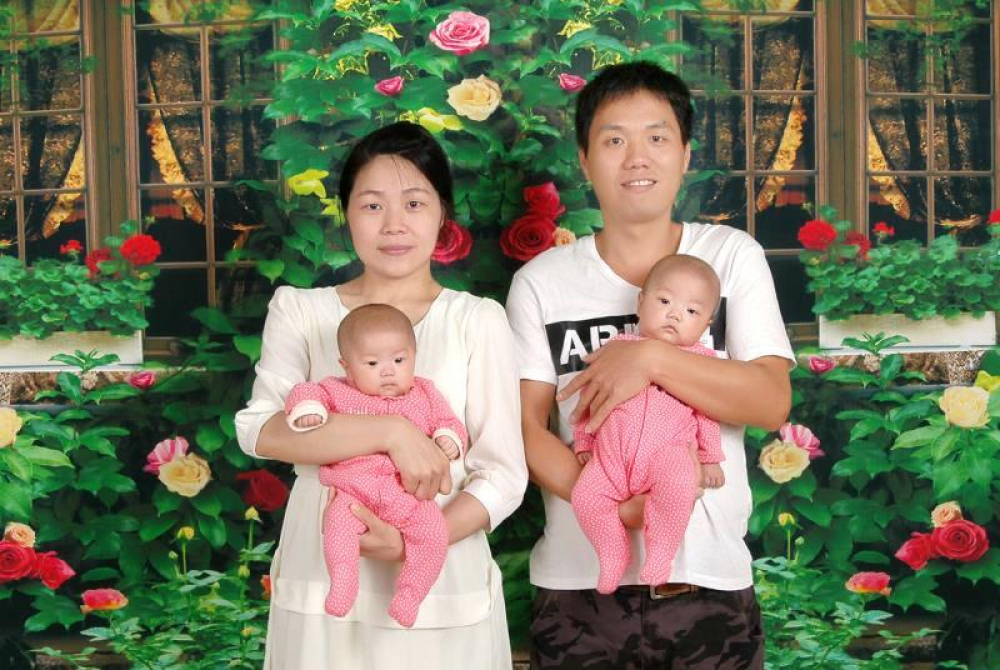陳小姐(左)與先生開心抱著一對雙胞胎女兒「一心、一意」。
