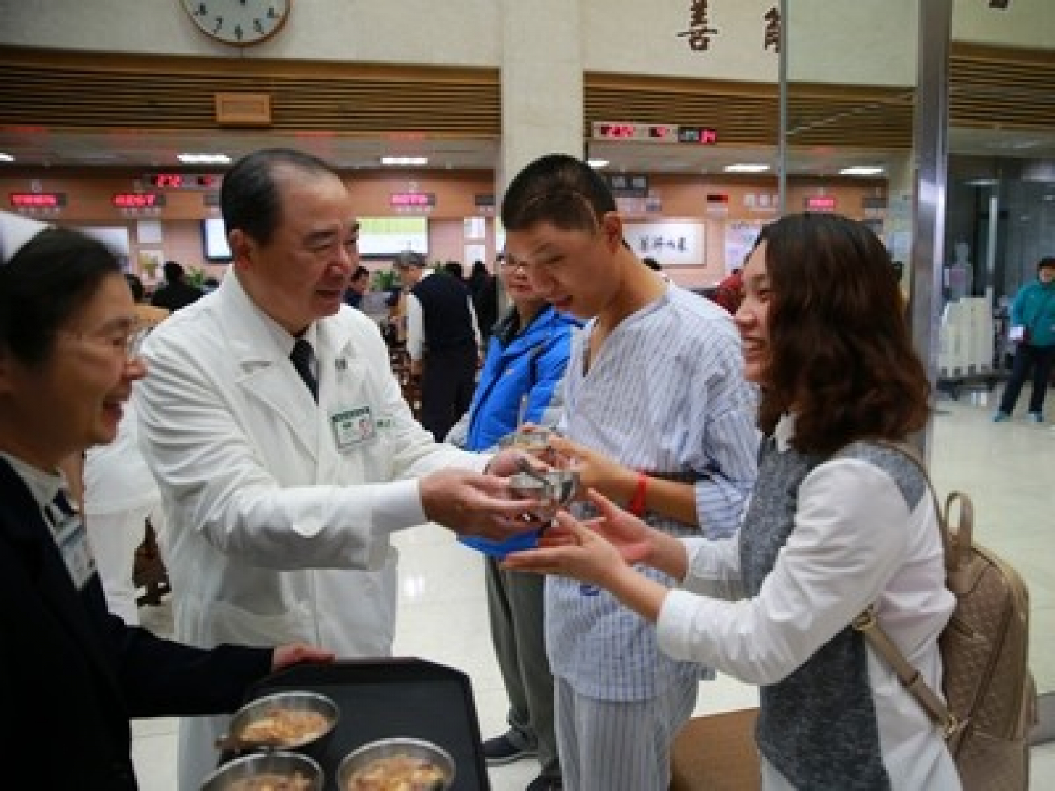 許文林副院長（左二）、護理部章淑娟主任（左一）帶領醫療團隊，將暖呼呼的臘八粥，送到每位民眾的手中。（攝影／楊國濱）