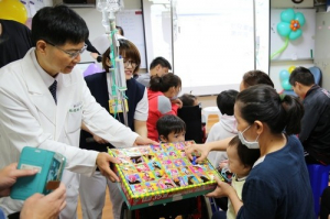 一般兒科主任林俊松邀家長帶著孩子玩抽抽樂。(楊國濱攝)