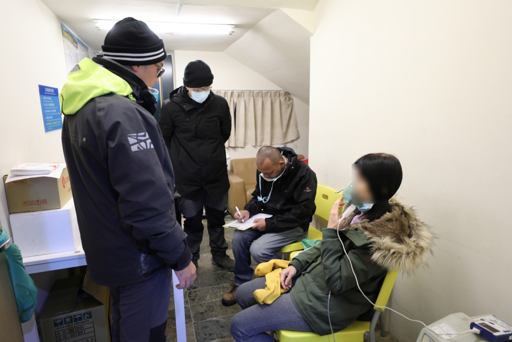 在松雪樓雪季醫療站駐點的花蓮慈院急診部醫護人員，為出現高山症狀的遊客進行給氧處置。