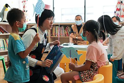 蘋果媽咪黃雪華（右一）前往一間間病房拜訪，邀請孩童們聽故事，並細心地帶領前往兒童遊戲室。